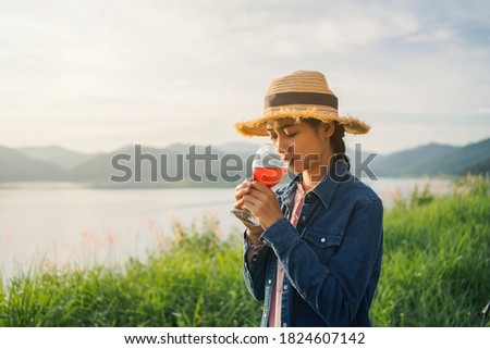Young Asian woman tasting tourist drinking wine on top of mountain.