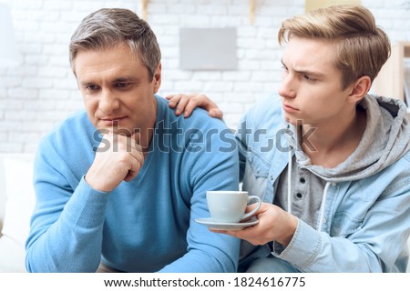 Son brought dad coffee to ask him for forgiveness. Dad takes offense at son while son tries to ask for forgiveness from him. Royalty-Free Stock Photo #1824616775