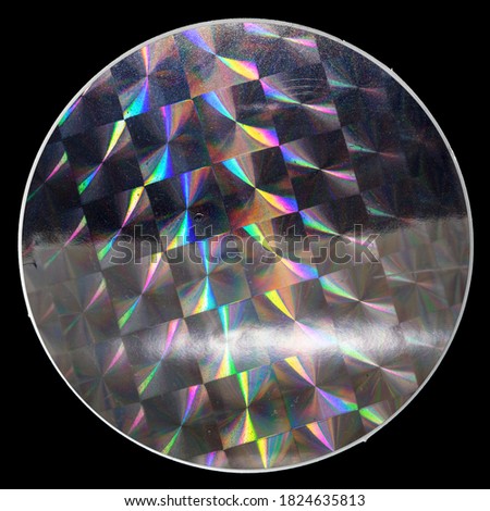 macro top shot of holographic foil sticker with cool grid pattern texture, holo sticker on real paper sheet isolated on black background. 