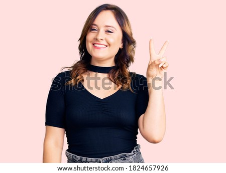 Young beautiful caucasian woman wearing casual clothes smiling with happy face winking at the camera doing victory sign. number two. 