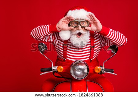 Photo of funky retired old man moped ride open mouth hold eyewear incredible speed wind wear santa x-mas costume suspenders sunglass boots striped shirt cap isolated red color background Royalty-Free Stock Photo #1824661088