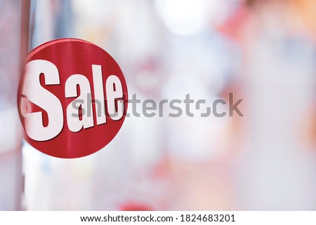 Shopping sale discount concept, Red sale label on shopping department store shelf with bokeh background with copy space.