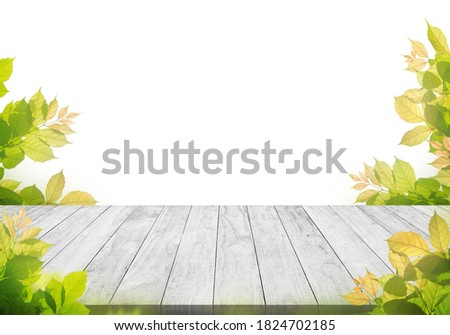 white wooden table top with spring green leafs as frame and free space for text

