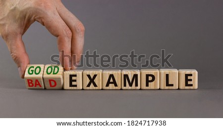Hand turns a cubes and changes the expression 'bad example' to 'good example'. Beautiful grey background. Business concept. Copy space. Royalty-Free Stock Photo #1824717938