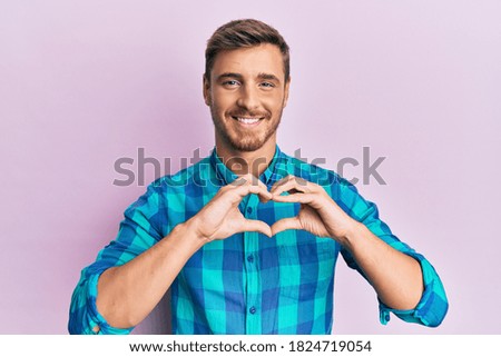 Handsome caucasian man wearing casual clothes smiling in love showing heart symbol and shape with hands. romantic concept. 