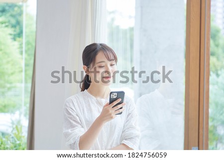Asian woman using the smart phone at home