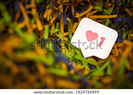 Like heart symbol. Like sign button, symbol with heart and one digit. Social media network marketing. Multicolored tinsel background.