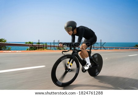 Asian cyclist practice bicycles on a triathlon on a seaside road. Royalty-Free Stock Photo #1824761288