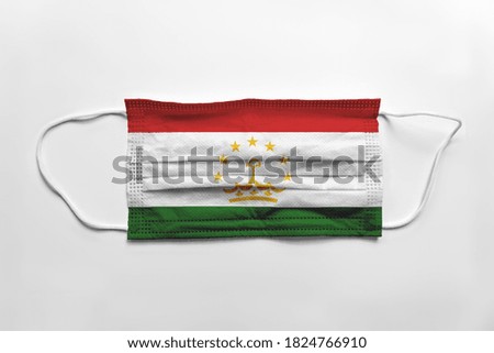 Face mask with Tajikistan flag printed, on white background, isolated.