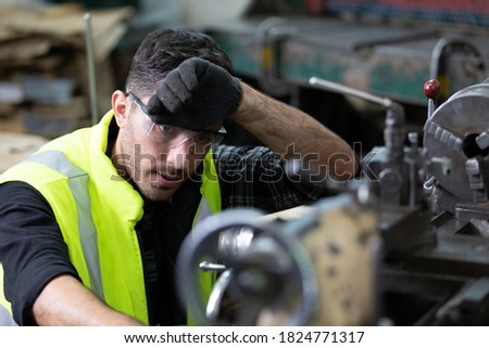 engineer man or factory worker feeling tired for working on the machine in factory Royalty-Free Stock Photo #1824771317
