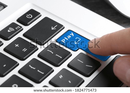 Woman pressing button Play on laptop keyboard, closeup. Online games concept