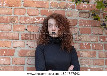young girl in gothic style on the background of a stone wall