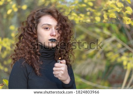 portrait of a young girl in gothic style with a lighter