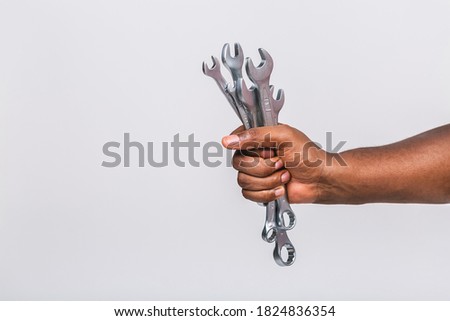 African american man's hand holding a spanners or wrench isolated on white background. Close up concept. High resolution product. 