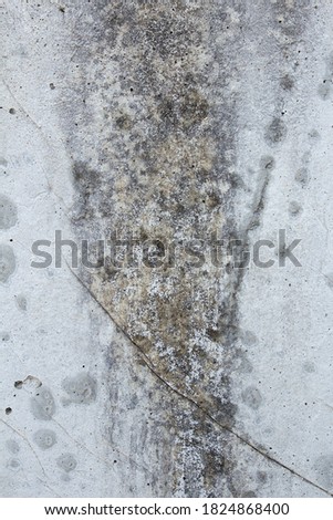 Effects of humidity on white concrete as a textured background. Wall with scratches and a large brown and gray stain. Abstract art.