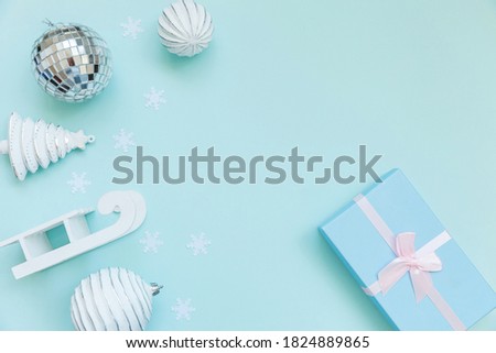 Simply minimal composition winter objects ornament sled fir tree ball gift box isolated blue pastel background. Christmas New Year december time for celebration concept. Flat lay top view copy space