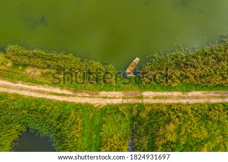Top down aerial view of small rowing boat near coast of lake