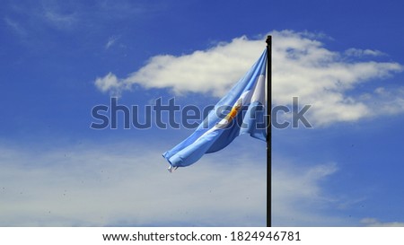 The Argentine flag on the mast against the cloudy sky.