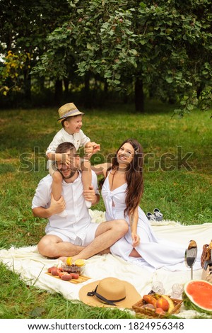 Loving parents with their son at picnic.