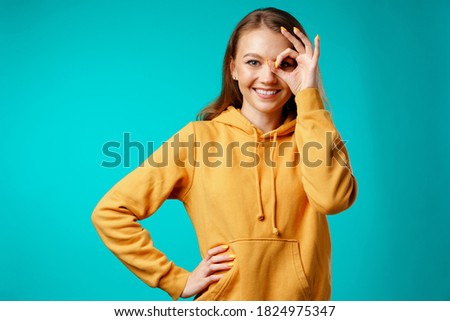 Young woman looking through hand binocular and smiling