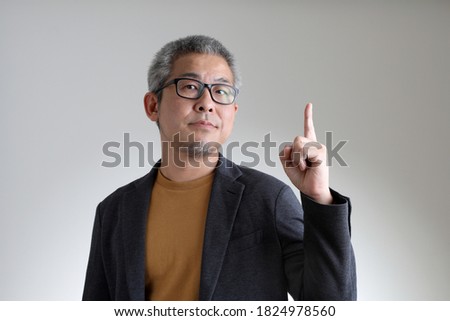 The Asian man in smart casual standing on the white background.