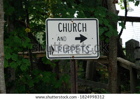 white church and puppets with arrow sign black letters
