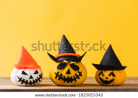Funny Halloween day decoration party, closeup halloween pumpkin head jack o lantern smile scary on wooden and copy space, studio shot isolated yellow background, Happy holiday concept