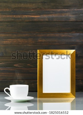 Picture mock up with golden frame and coffee cup over table with wood wall background