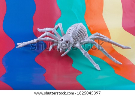 Sinister Spider skeleton with red eyes on bright wavy brightly colored background