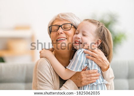 A nice girl and her grandmother enjoy sunny morning. Good time at home.  Royalty-Free Stock Photo #1825062035