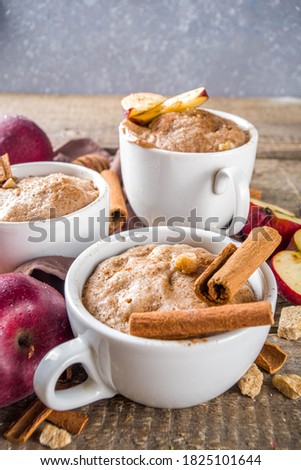 Quick autumn dessert idea. Autumn apple pie mugcake with red apples, cinnamon, spices, Rustic wooden background copy space Royalty-Free Stock Photo #1825101644