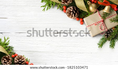 Christmas frame composition made of gift box, fir branches, cones on white wooden background. Flat lay, top view, copy space