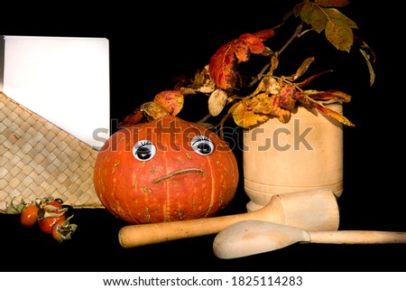 Nice happy pumpkin with eyes, white paper card, wooden spoon, mortar and pestle. Thanksgiving, Halloween concept. Copy space, mock-up. 