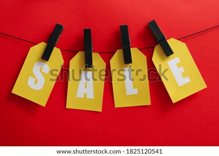 Text Sale hanging on the clothesline on red background