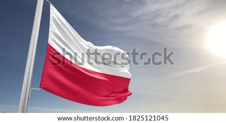 Poland national flag cloth fabric waving on beautiful sky.