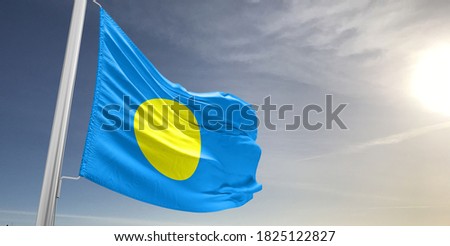 Palau national flag cloth fabric waving on beautiful sky.