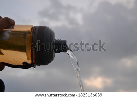 Pouring water from a bottle. Picture taken in a natural background.