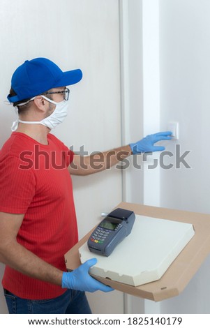 Delivery guy with protective mask holding pizza box at the door.