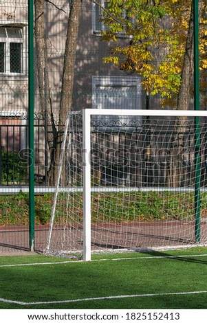 Football goal on a green field on a sunny autumn day. Sports equipment on the street.