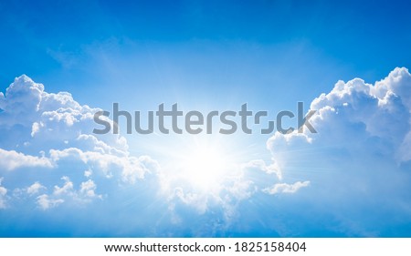 Beautiful religious image - bright light from heaven, light of hope and happyness from skies. Sun shines in blue sky above white clouds. Royalty-Free Stock Photo #1825158404