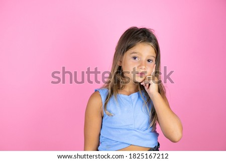Young beautiful child girl over isolated pink background thinking and looking to the side