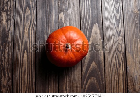 pumpkin for Halloween. Thanksgiving Day. orange ripe pumpkin lies on a dark wooden table. preparation for the holiday.