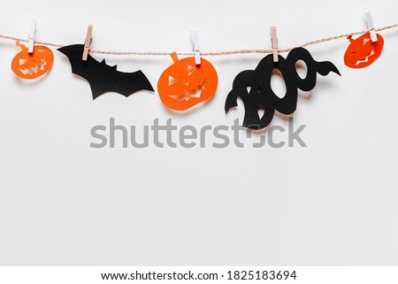 Happy halloween holiday concept. Bats, pumpkins and ghosts on rope with clothespin on white isolated background