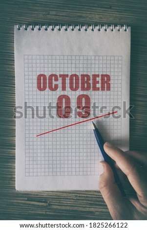 october 9th. Day 9 of month,  Close up of human hand with pen on notepad with red underlined date.  autumn month, day of the year concept.