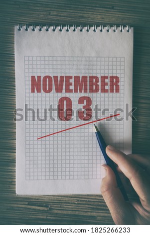 november 3rd. Day 3 of month,  Close up of human hand with pen on notepad with red underlined date.  autumn month, day of the year concept.