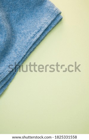 A blue soft towel on a yellow surface