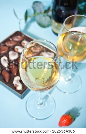 Champagne or wine in glasses and box of chocolates.