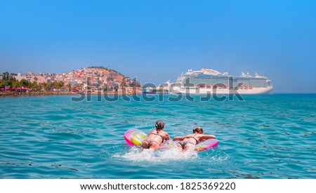 Girls in bikini lying on air bed -    The cruise ship is located on Kusadasi Island in the port of Kusadasi, Turkey