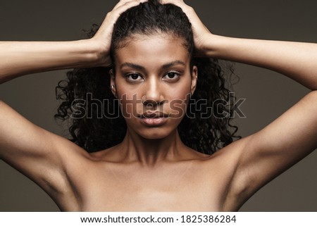 Image of a beautiful young african woman with healthy skin isolated over grey wall background