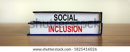 Books with text 'social inclusion' on beautiful wooden table. White background. Business concept. Copy space.
